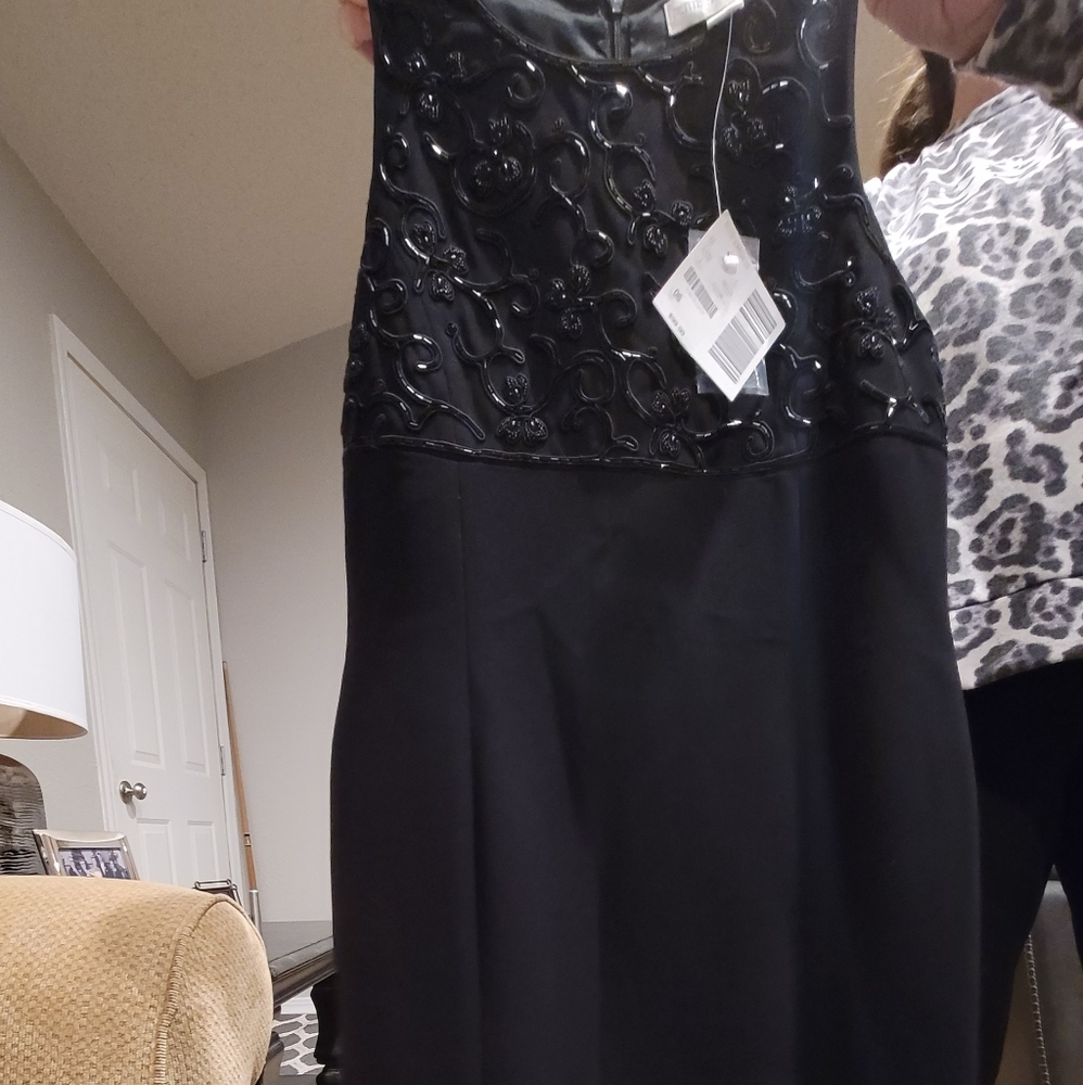 Black cocktail dress with sequins accents on chest.